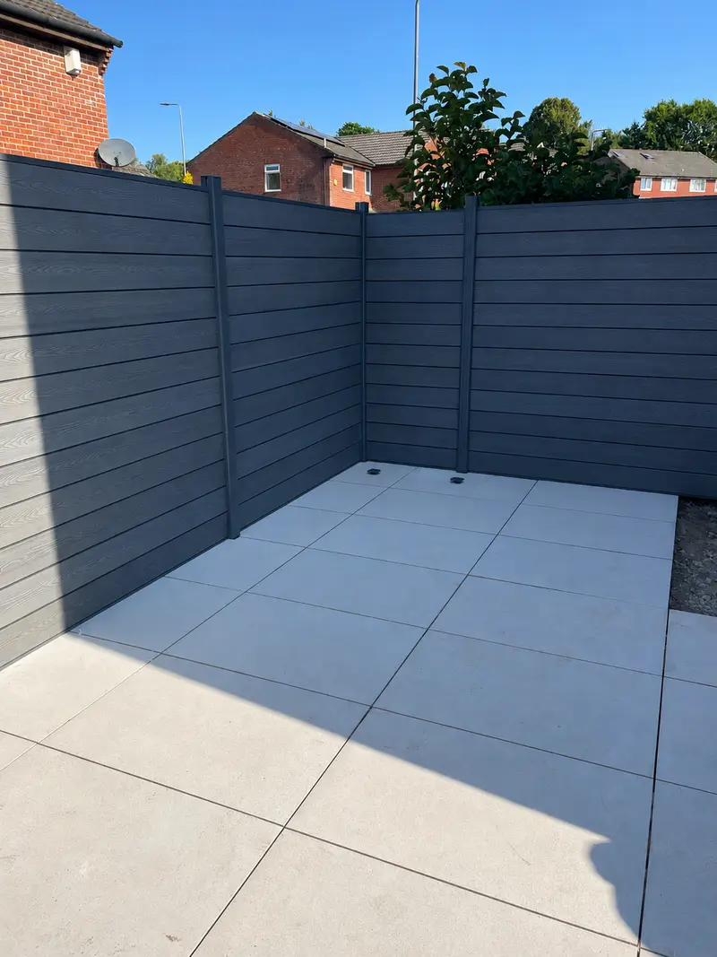 Grey composite fence panels above a porcelain patio